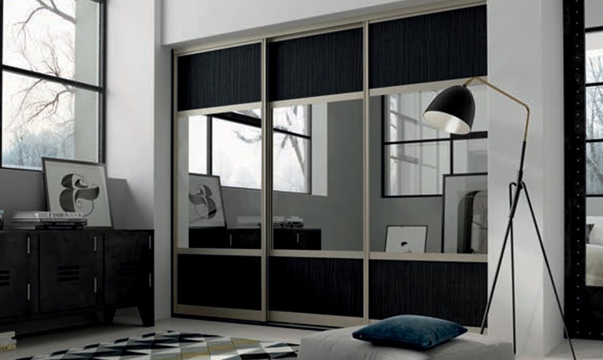 Bespoke Glide sliding wardrobe doors with mirror and black wood-effect panels in a bright bedroom